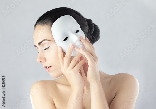 Młoda kobieta trzymająca maskę obok twarzy