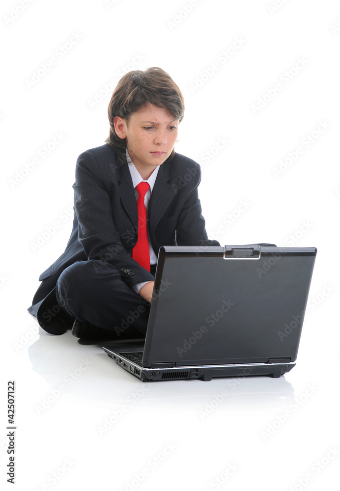 boy in business suit sitting in front of computer boy in business suit sitting in front of computer