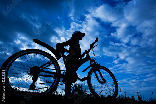 Fototapeta Naklejka Na Ścianę i Meble -  cyclist silhouette on a blue sky