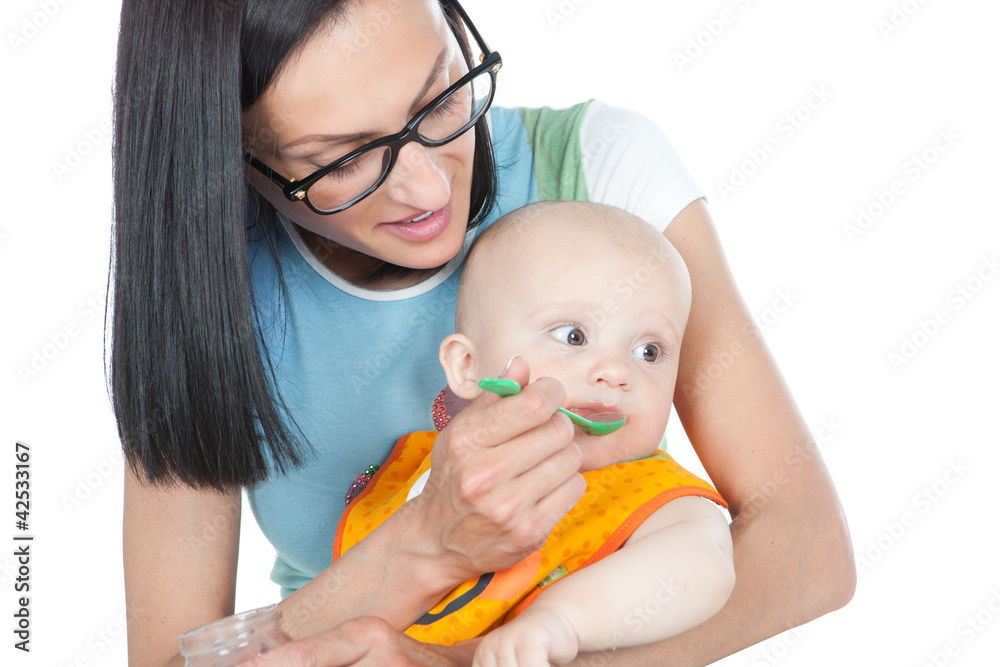 young mother feeding her baby with a spoon young mother feeding her baby with a spoon