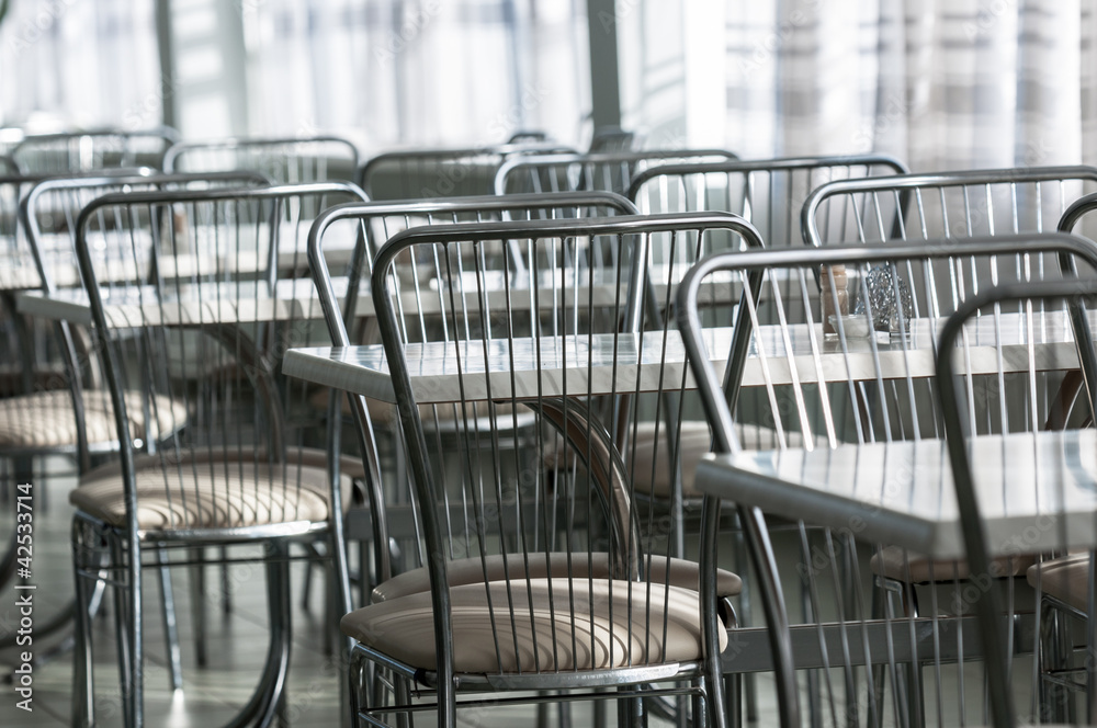 Photo of a canteen with metal chairs and tables Photo of a canteen with metal chairs and tables
