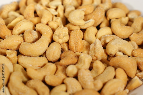 Delicious cashew nuts isolated on a white plate - Close up