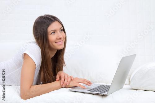 successful woman lying on a sofa with laptop