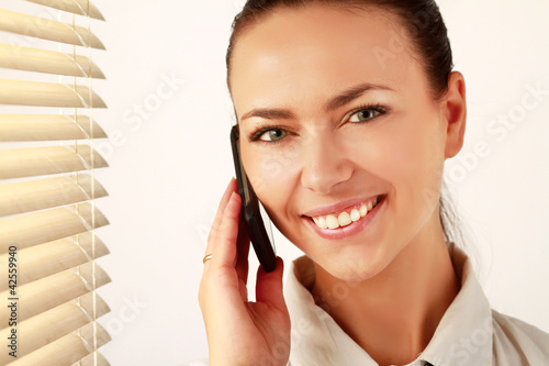 Canvas Print Woman is standing in the office near window and talking on phone