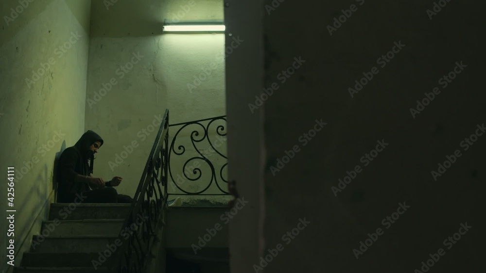 Young drug addict shooting up heroin in abandoned house