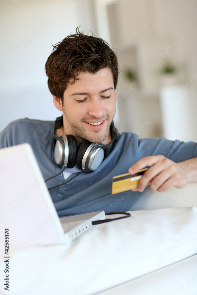 Young man buying music on internet with tablet Young man buying music on internet with tablet