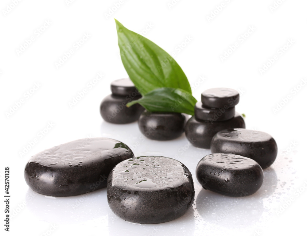 Fototapeta premium Kamienie Spa z kropli i zielonych liści na białym tle