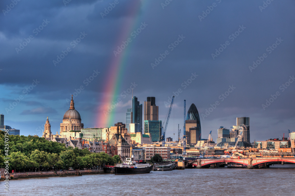 Naklejka premium Panoramę londyńskiej dzielnicy finansowej nad Tamizą z tęczą