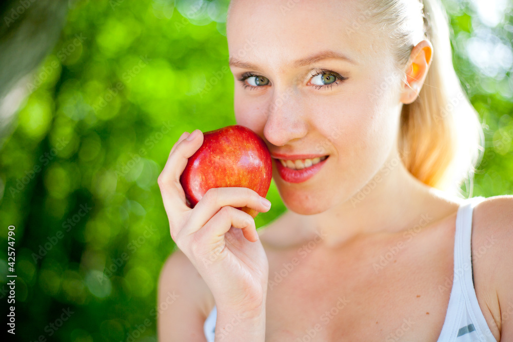 young beautiful fit and healthy woman holding an apple and smili young beautiful fit and healthy woman holding an apple and smili