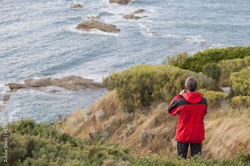 Man with red jacket at the coast