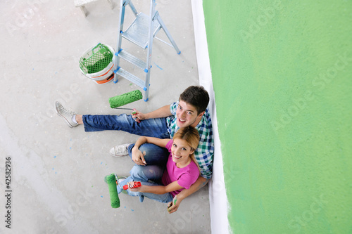 happy young cople relaxing after painting in new home photo