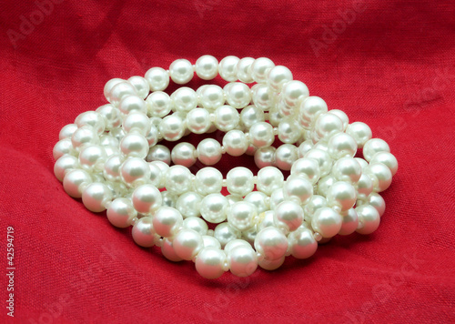 Pearl necklace on red background