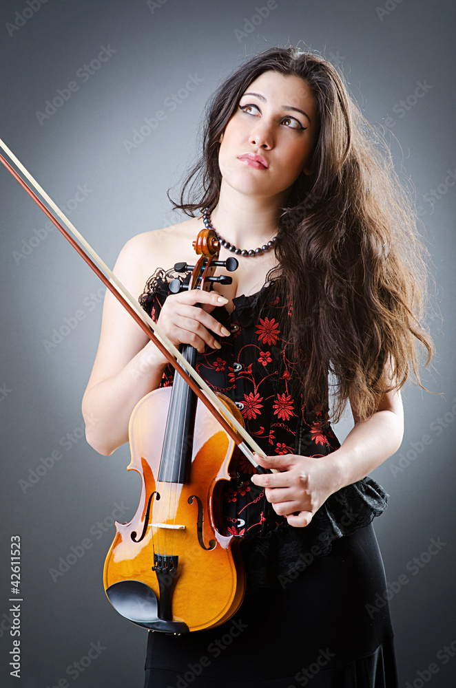 Fototapeta premium Female violin player against background