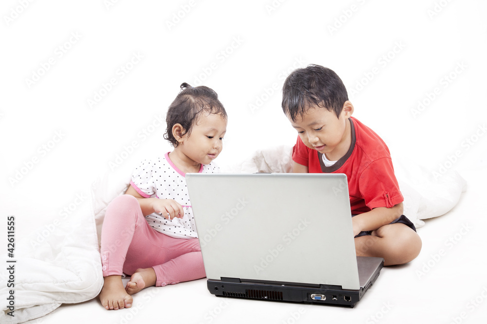 Asian sibling using laptop