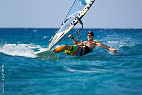 Young man surfing the wind in splashes of water