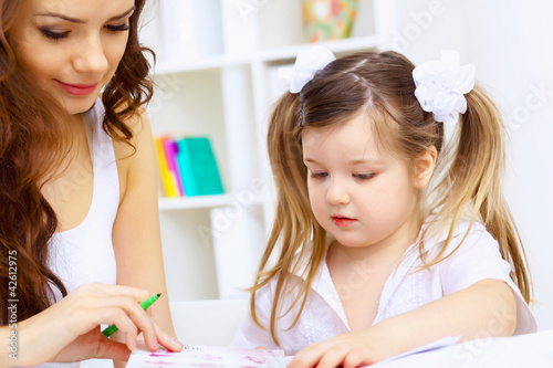 Little girl and her mother studying