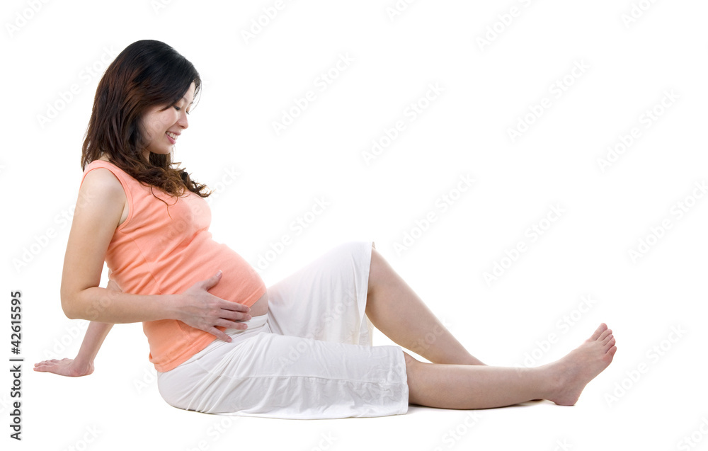 Asian pregnant sitting on the floor holding her belly Asian pregnant sitting on the floor holding her belly