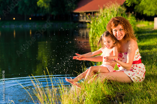 mother and young douther at the lake enjoying a sunset photo