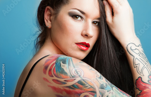 Beautiful girl with stylish make-up and tattooed arms.