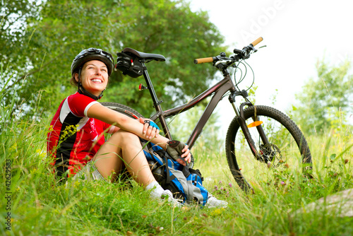 Fototapeta Naklejka Na Ścianę i Meble -  Happy Young Woman riding bicycle outside. Healthy Lifestyle