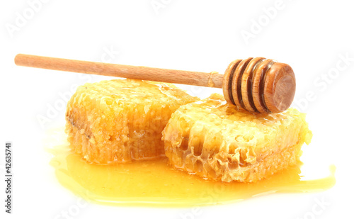 golden honeycombs and wooden drizzler with honey isolated