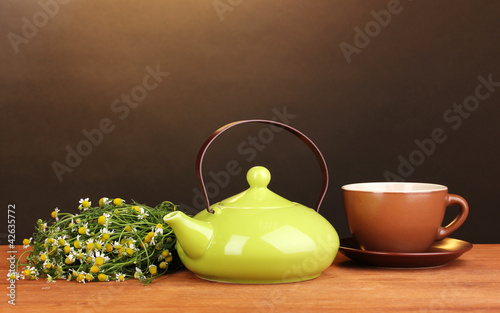 Teapot and cup with chamomile tea photo