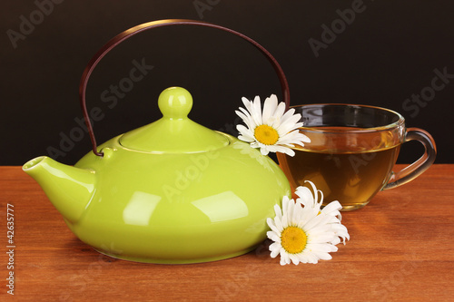 Teapot and cup with chamomile tea photo