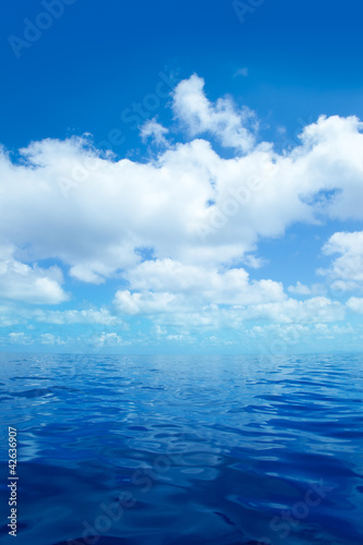 Blue calm sea water in with clouds mirror surface