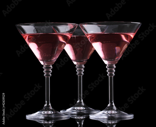 Red cocktail in martini glasses isolated on black