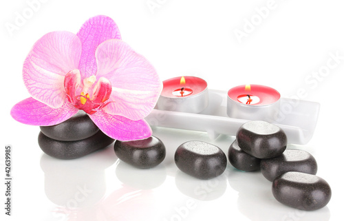 Spa stones with orchid flower and candles isolated on white