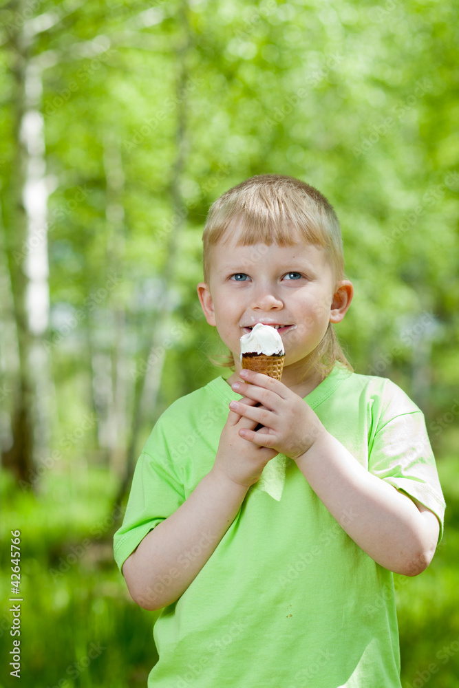 young boy eating a tasty ice cream outdoors