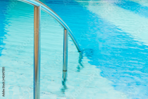 Canvas Print Swimming pool Stairs with hand-rails on water background.