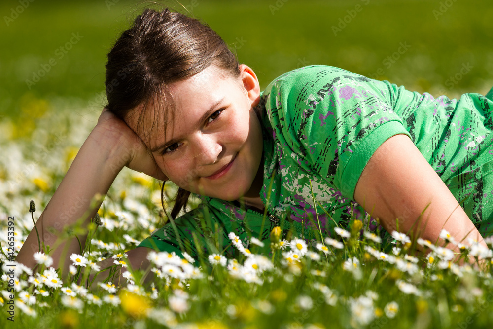 Young girl laying on the daisy flowers field Young girl laying on the daisy flowers field
