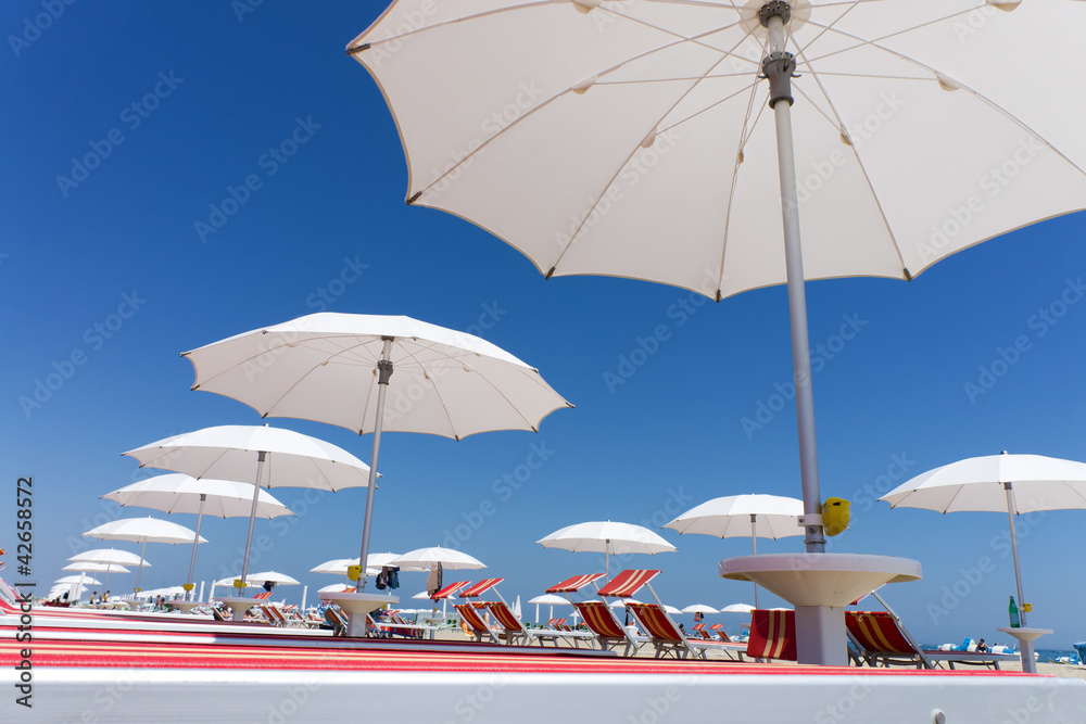 white beach umbrellas on Rimini beach, Italy
