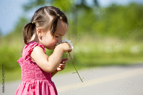toddler smelling flower
