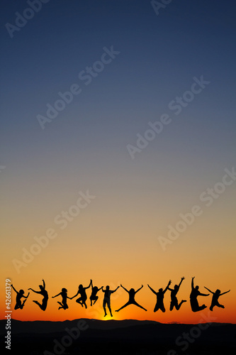 silhouette of teenagers jumping in sunset for fun