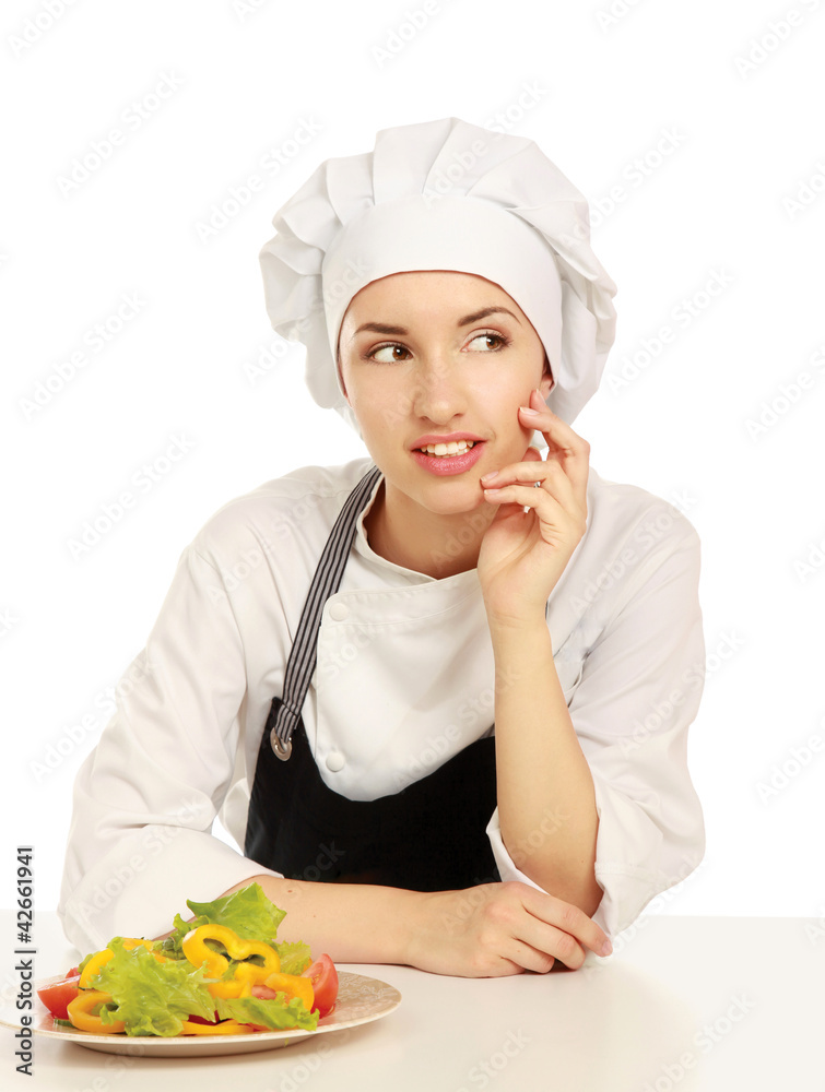 Pretty cook chief sitting on the table with salad Pretty cook chief sitting on the table with salad