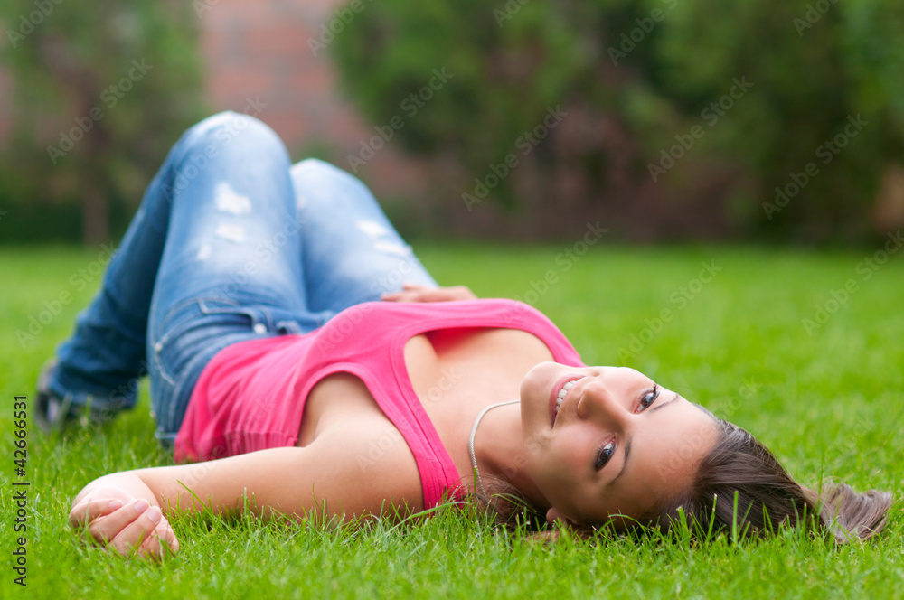 Beautiful girl lying on the grass on calm spring day Beautiful girl lying on the grass on calm spring day
