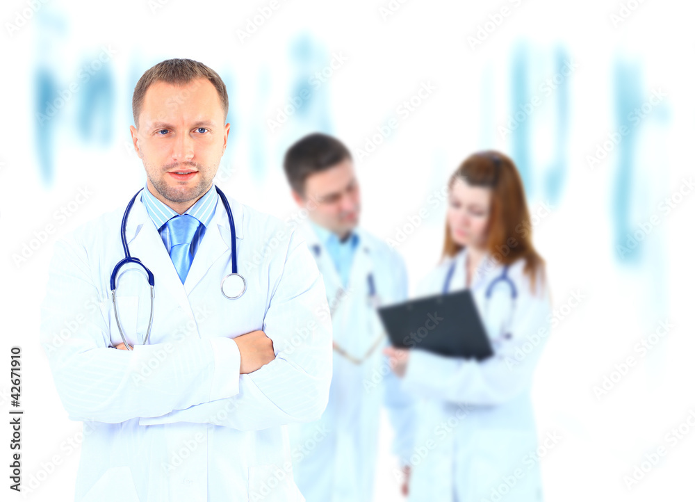 Portrait doctor smiling with colleagues in background Portrait doctor smiling with colleagues in background