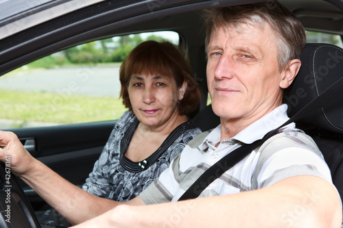 Senior husband and wife sitting in land vehicle