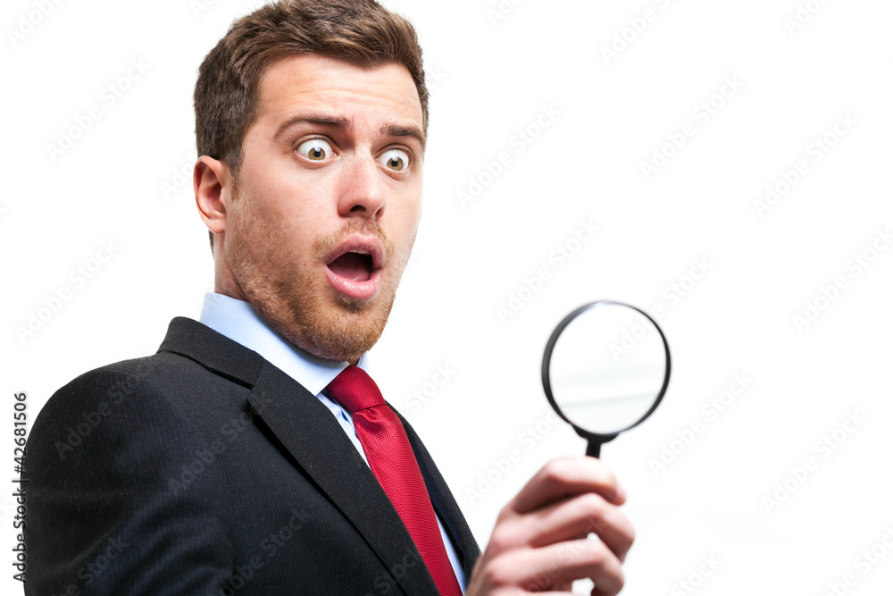 surprised business man looking through loupe surprised business man looking through loupe