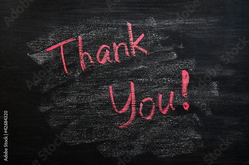 Thank you written with red chalk on a smudged blackboard