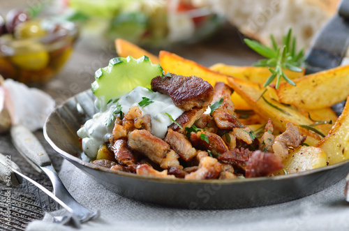 Deftige Gyrospfanne mit Bauernsalat, Pitabrot und Oliven