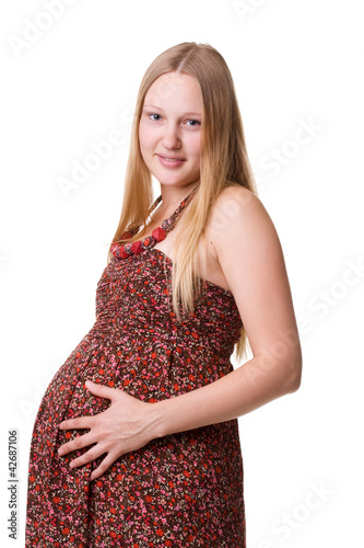 Studio portrait of pregnant woman holding her belly.