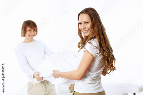 Young couple fighting with pillows