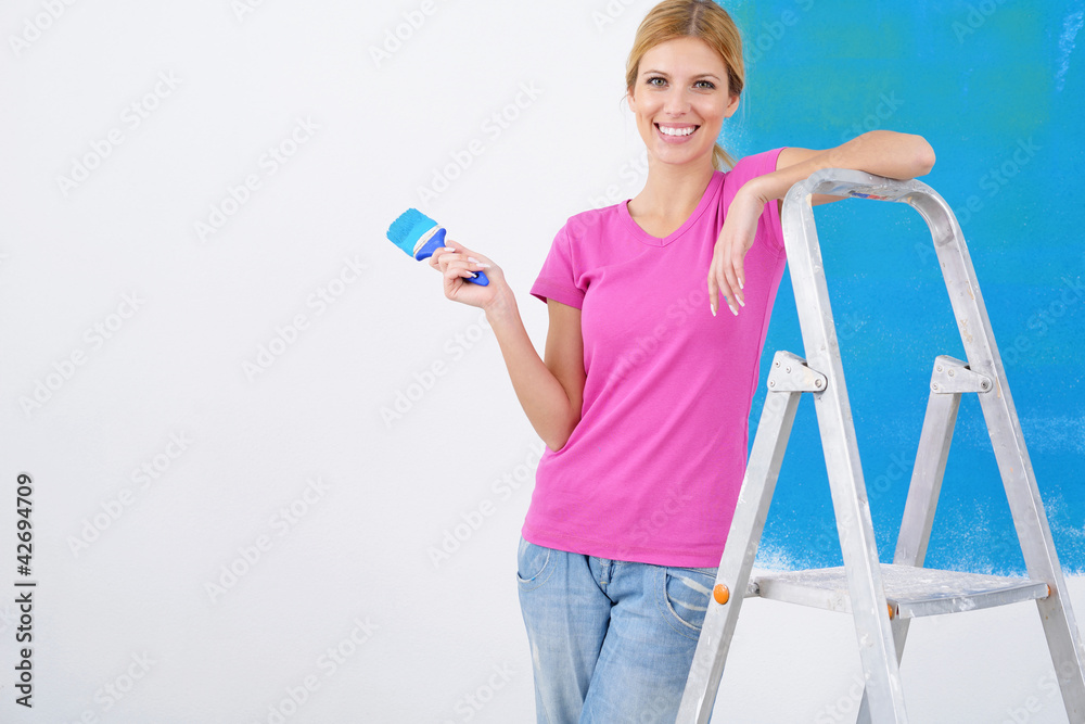 happy smiling woman painting interior of house happy smiling woman painting interior of house