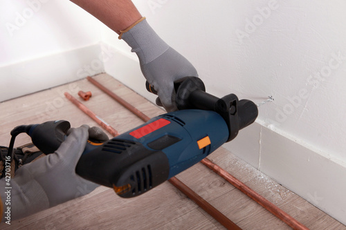 someone drilling a hole in a wall