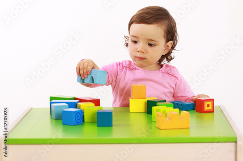 Ein Kleinkind baut einen Turm aus Bausteinen