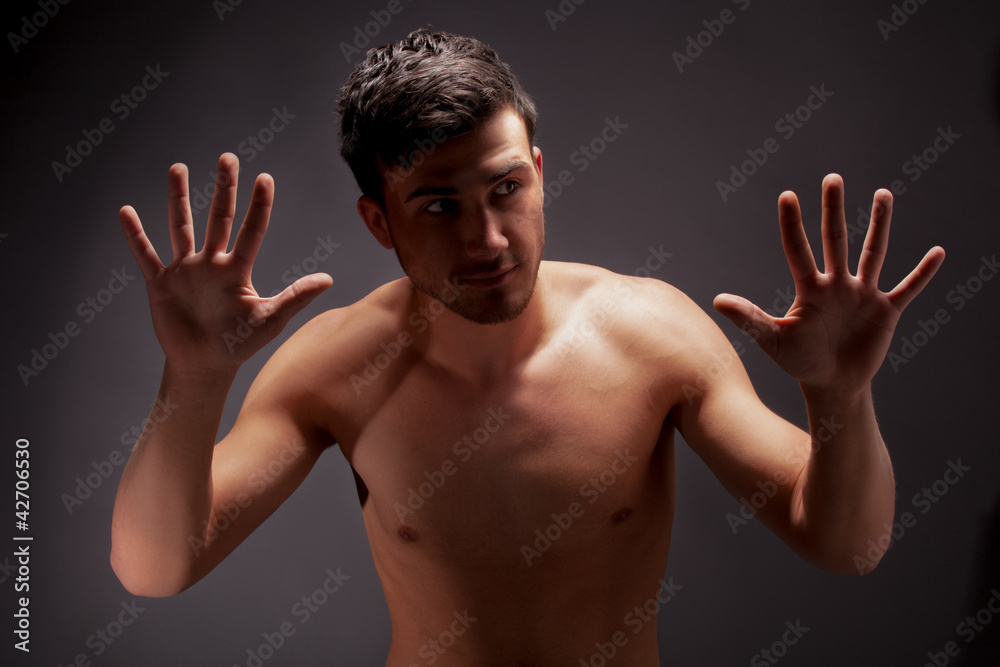 young muscular man with a bare chested on black. young muscular man with a bare chested on black.