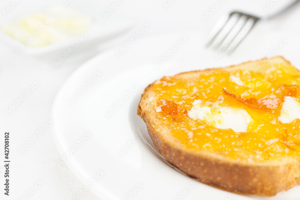 French toast close up, orange marmalade, butter, fork on white t